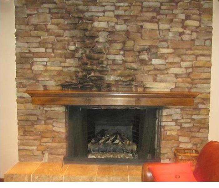 a stone fireplace with soot stain on the stone
