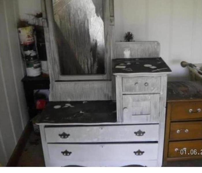an antique white vanity damaged by fire