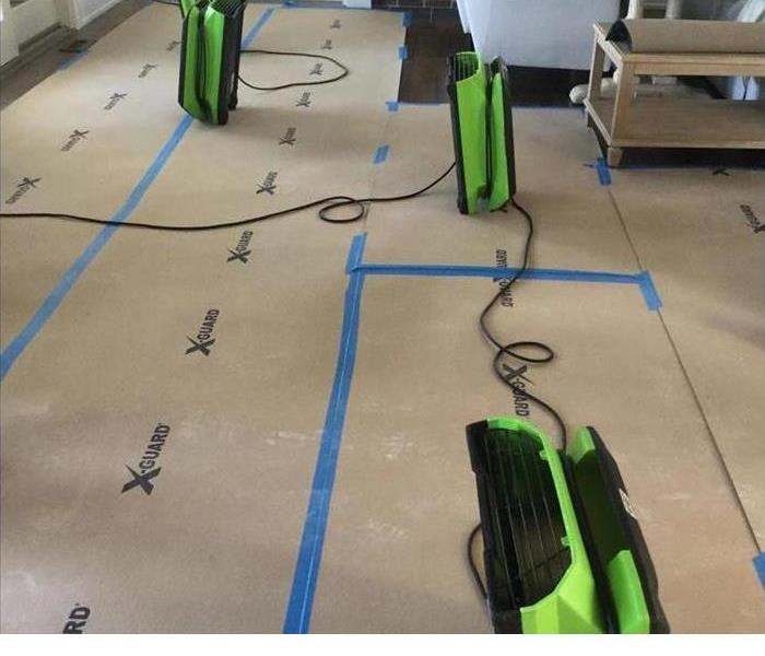water damaged floor with SERVPRO drying machines on top working to get the floors dry